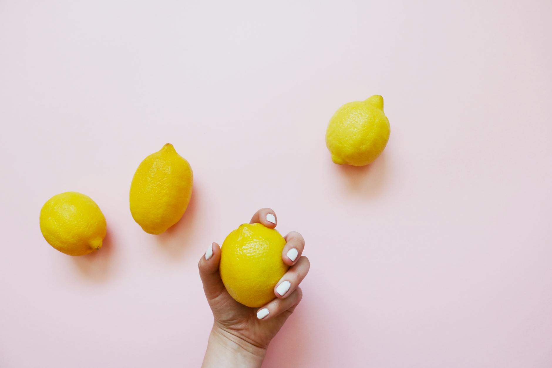A hand holding an orange vibrator against a minimalistic purple backdrop, showcasing modern sensuality