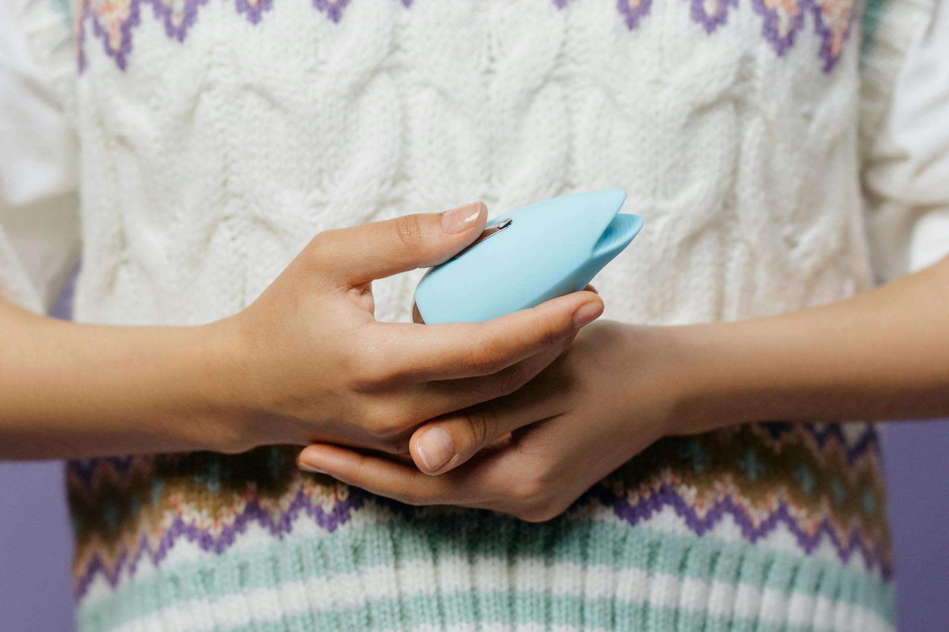 Woman holding a blue vibrator with contemplative expression during emotional recovery
