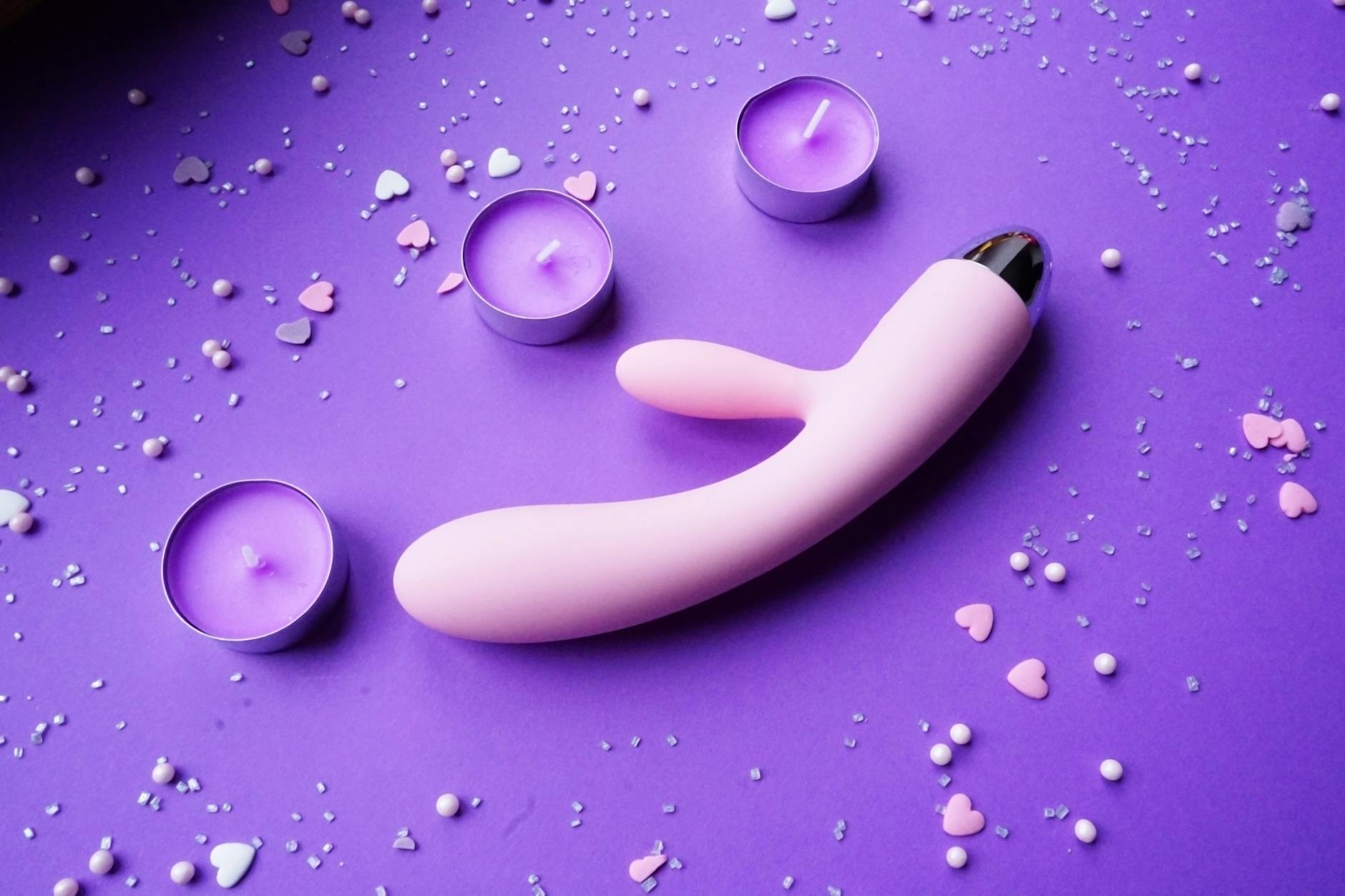 A yellow lemon vibrator surrounded by fresh fruit on a bright yellow background